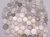 a pile of silver coins on a white surface