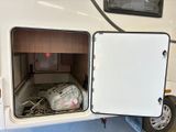 the inside of a camper with a bed and a refrigerator