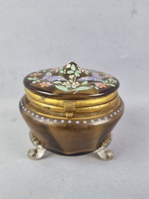 une image représentant une petite boîte en or ornée d'un motif floral