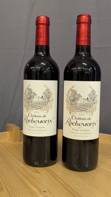 deux bouteilles de vin rouge posées sur une table en bois