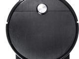 un aspirateur robot noir sur fond blanc
