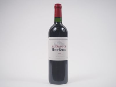 la bouteille de vin rouge est posée sur une surface blanche
