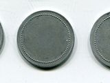 three oval metal tags with holes on them on a white surface