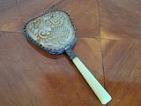 a small mirror on a wooden table with a wooden handle
