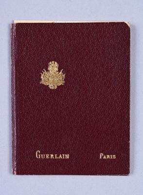 an old passport with a gold emblem on it sitting on a white surface