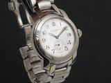 a silver watch with a white face on a black background