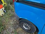 a blue van that is parked on the side of the road