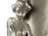 a statue of a woman with a towel on her head next to a vase