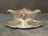 un service en argent ancien composé d'une assiette et d'une soucoupe posée dessus