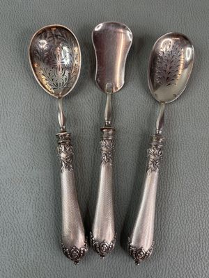 three spoons and a spoon rest on top of a table