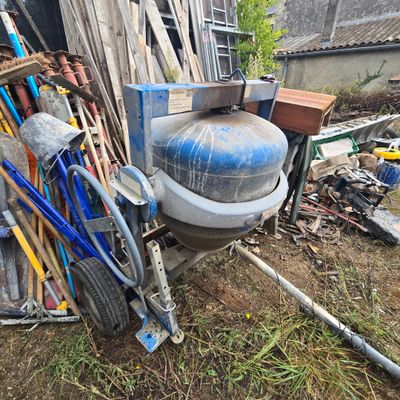 des toilettes posées dans l'herbe, à côté d'un tas de bric-à-brac