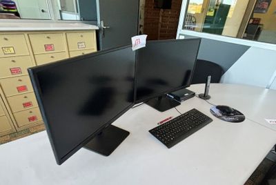 un bureau équipé de deux écrans et d'un clavier