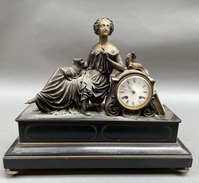 une statue de femme assise au sommet d'une horloge