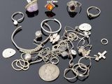 plusieurs bagues et bracelets posés sur une table, à côté d'une pièce de monnaie