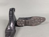 pair of black leather shoes with studded soles on a white surface