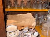 a yellow shelf with a bunch of glassware on it