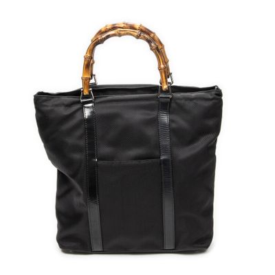 un sac fourre-tout noir avec des anses en bambou sur fond blanc