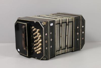 un vieil accordéon noir posé sur une table blanche