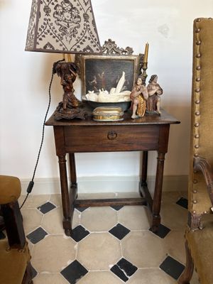 a small table with a lamp on top of it in a room