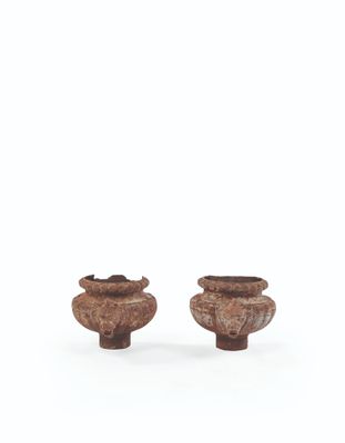 two small wooden vases sitting next to each other on a white surface