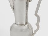 silver plated coffee pot with a curved handle on a white background