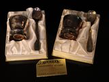 two silver spoons and a silver cup in a box