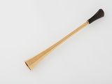 a wooden stick with a black handle sitting on a white surface