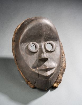 une image représentant une sculpture du visage d'un homme sur un morceau de bois