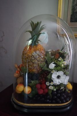 un ananas sous une cloche en verre, posé sur une table