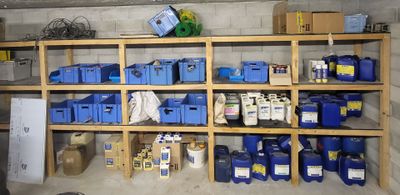 de nombreux bacs et boîtes bleus sur les étagères du garage