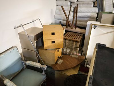 a pile of boxes and chairs in the middle of a room