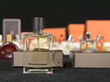 bottles of perfume are lined up on a table with orange boxes