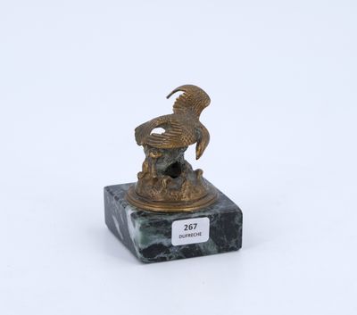 une statue en bronze représentant un oiseau, posée sur un socle en marbre