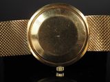 an image of a close up of a gold watch on a black surface
