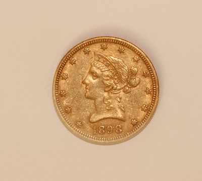a close up of a gold coin on a white surface