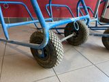 three blue carts that are sitting on a tiled floor