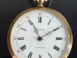 a gold pocket watch with roman numerals on it