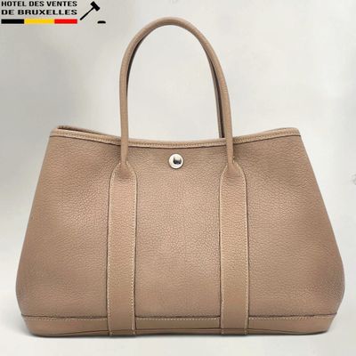 a beige leather handbag on a white background