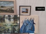 many paintings on display on a table in a room