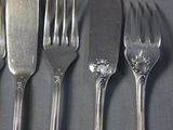 four forks and a knife on a table