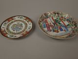 two plates with asian designs on them sitting on a table