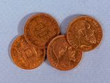 Quatre types différents de pièces de monnaie britanniques sont représentés sur un fond blanc