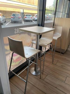 tables and chairs in front of a window with a view of a parking lot