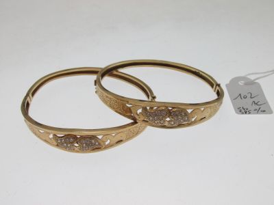 paire de bracelets rigides couleur or, ornés de diamants de chaque côté
