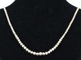un collier de perles blanches autour du cou d'un mannequin