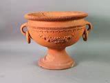 a large orange vase sitting on a gray surface