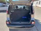 a small car with its trunk open in the parking lot