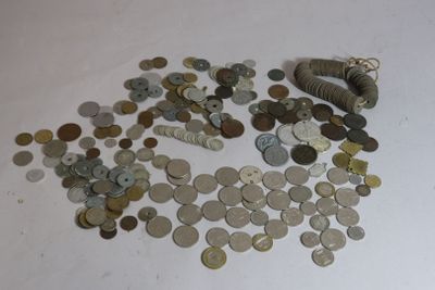 a pile of coins on a table with a roll of money