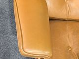 a brown leather chair and ottoman in a room