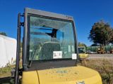 un gros plan d'un tracteur jaune dont le pare-brise est cassé